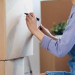 A Girl Is Labeling Moving Boxes For Moving